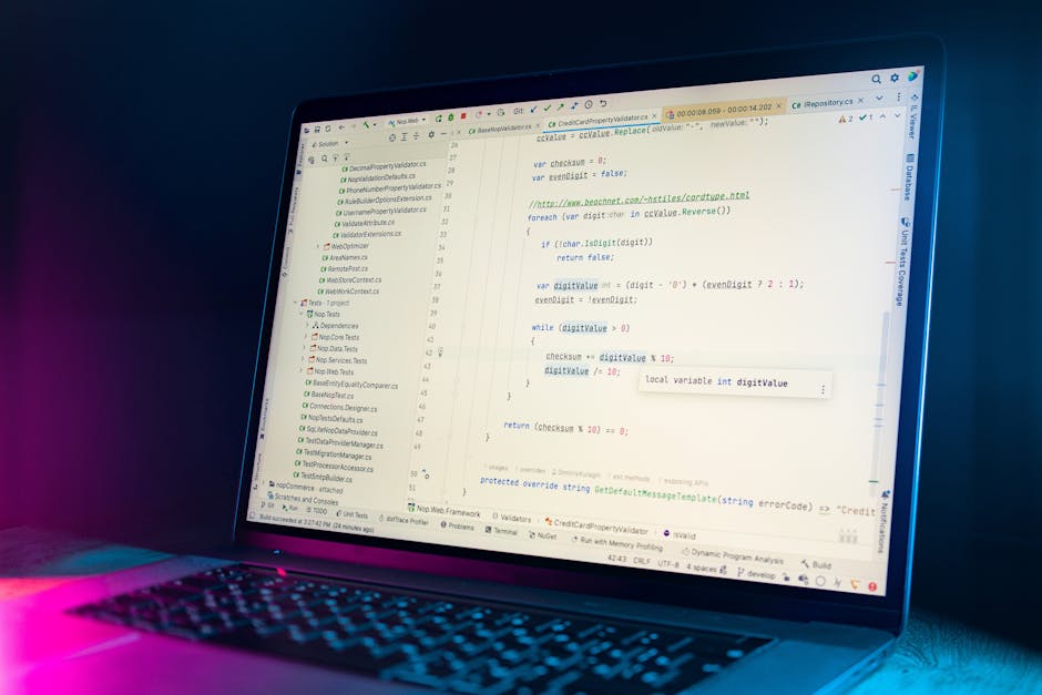 Close-up view of a computer screen displaying lines of colorful programming code, with a blurred background. The code features various syntax elements in different colors, including keywords, variable